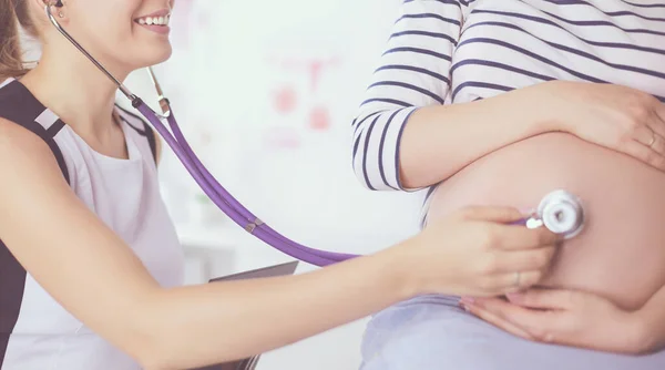 Retrato de Jovem médica examinando mulher grávida na clínica . — Fotografia de Stock