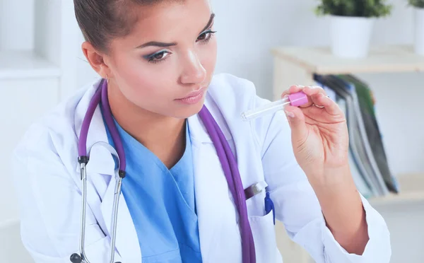 Portrait of pretty female laboratory assistant analyzing a blood sample at hospital near laptop — Stock Photo, Image