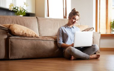 oturma odasında yere üstünde laptop ile mutlu bir kadın