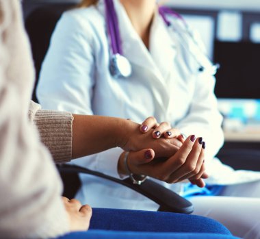 Doktor ya da hemşire yaşlı bayanların elini tutuyor.