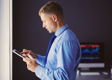 Ofiste dokunmatik ayaklı gülümseyen iş adamı.