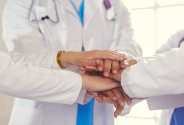 Doktorlar ve hemşireler el ele tutuşuyor. Beyazda izole edilmiş