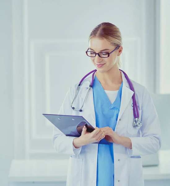 Smiling female doctor with a folder in uniform standing — Stock Photo, Image