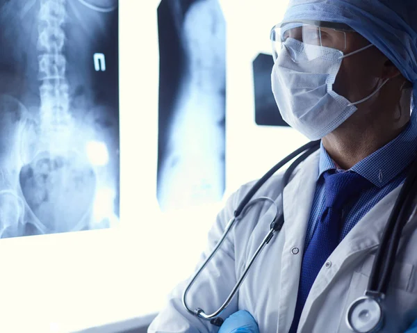 Genç doktor, izole edilmiş beyaz arka planda röntgen görüntüsü arıyor. — Stok fotoğraf