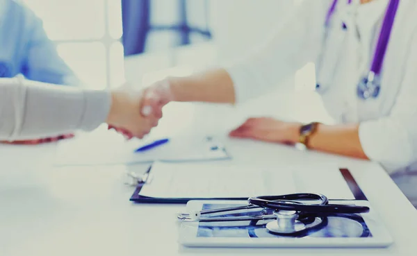 Woman doctor handshaking with a senior couple