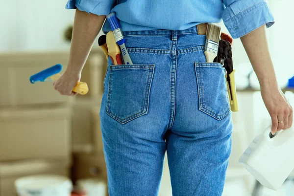 Mujer muy olorosa pintando la pared interior del hogar con rodillo de pintura — Foto de Stock