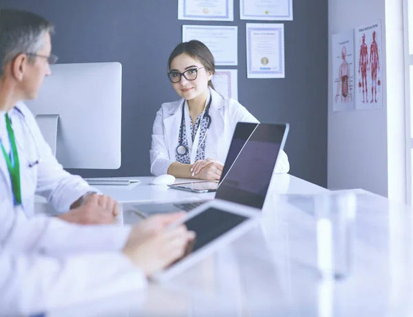 Serious medical team using a laptop in a bright office — Stock Photo, Image