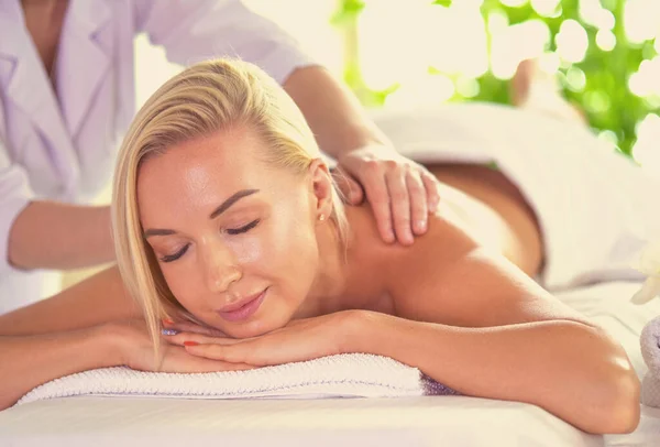 Chica joven y hermosa relajarse en el salón de spa. Terapia de masaje sobre fondo estacional de verano o primavera —  Fotos de Stock