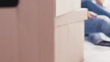 Genç ve çekici bir çift yerde oturan ve yeni evlerinin tabletine bakıp tasarımı düşünüyorlar. Kapalı