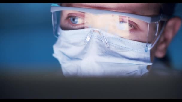 Young Medical Researcher Working In A Dark Medical Laboratory und betrachtet die Ergebnisse auf einem Monitor — Stockvideo