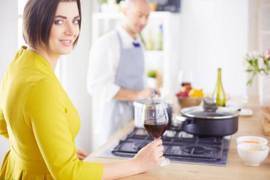 Aşık çekici bir çift yemek pişirir ve onlar romantik bir akşam yemeği pişirirken mutfakta şarap açar.