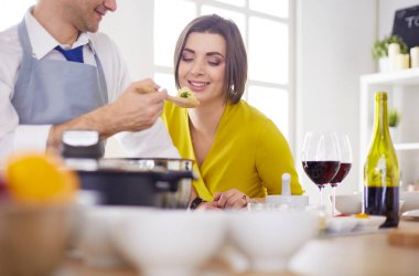 Evdeki mutfakta birlikte yemek pişiren çift.