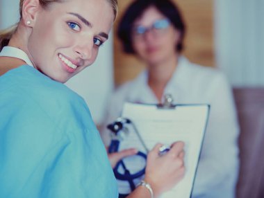 Kadın doktor, kadın hastasına teşhisi açıklıyor.