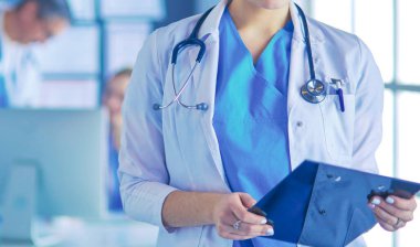 Hastane lobisinde tablet bilgisayar kullanan kadın doktor.