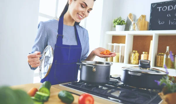 Cozinhar mulher na cozinha com colher de madeira — Fotografia de Stock