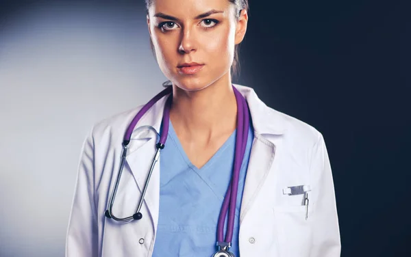 Young doctor woman with stethoscope isolated on grey — Stock Photo, Image