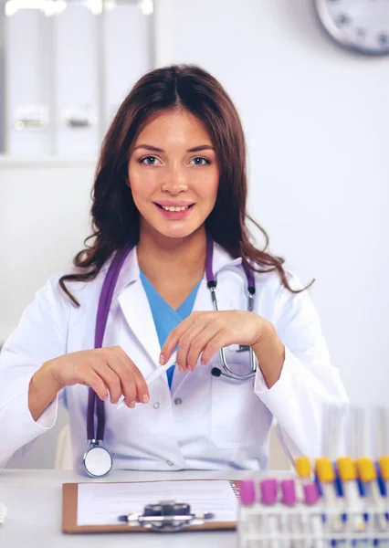 Woman researcher is surrounded by medical vials and flasks, isolated on white background — Stock Photo, Image