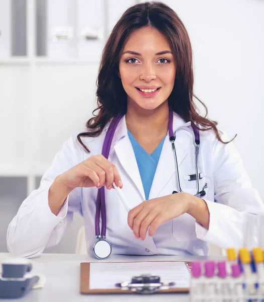 Woman researcher is surrounded by medical vials and flasks, isolated on white background — Stock Photo, Image