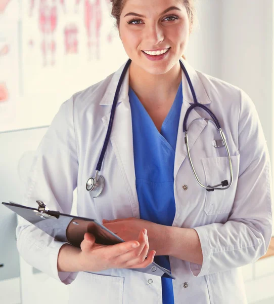 Woman doctor standing with folder at hospital — Stock Photo, Image