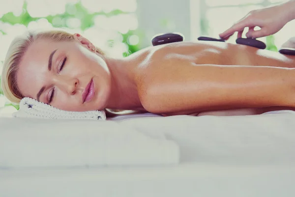 Menina jovem e bonita relaxante no salão de spa. Terapia de massagem durante o verão sazonal ou fundo de primavera — Fotografia de Stock