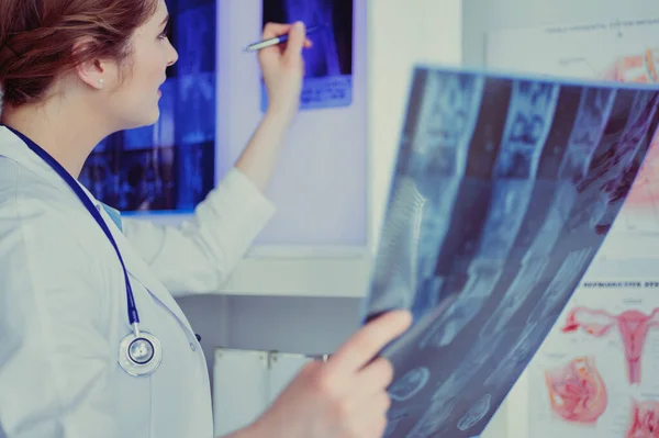 Νεαρή επαγγελματίας γιατρός που εξετάζει τους ασθενείς x-ray — Φωτογραφία Αρχείου