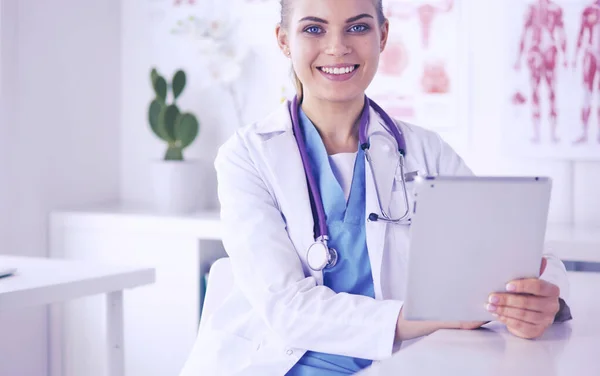 Primer plano Retrato de una médica amigable con estetoscopio y tableta en las manos. — Foto de Stock