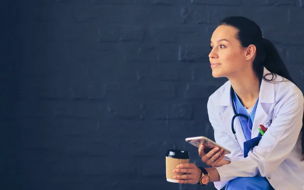 Een jonge vrouwelijke dokter die bij je telefoon zit. Vrouwelijke artsen. — Stockfoto