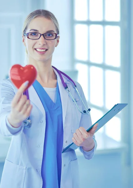 Médica com o estetoscópio segurando o coração — Fotografia de Stock