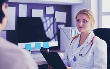 Kadın doktor, kadın hastasına teşhisi açıklıyor.