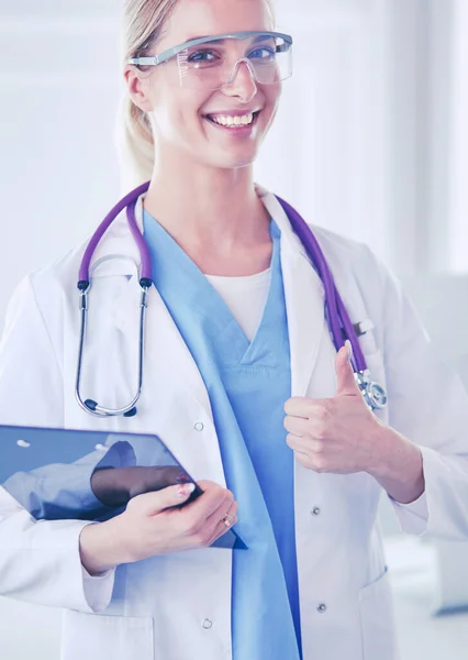Mujer doctora sonriente en uniforme azul con estetoscopio mostrando gesto de mano de signo aceptable aislado sobre fondo blanco —  Fotos de Stock