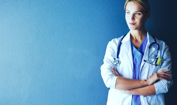 Porträtt av ung kvinna läkare med vit rock stående på sjukhus. — Stockfoto