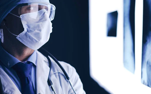 Молодий лікар дивиться рентгенівське зображення на ізольованому білому тлі — стокове фото