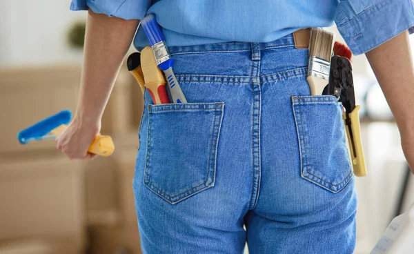 Mooie glimlachende vrouw schilderen interieur muur van huis met verfroller — Stockfoto