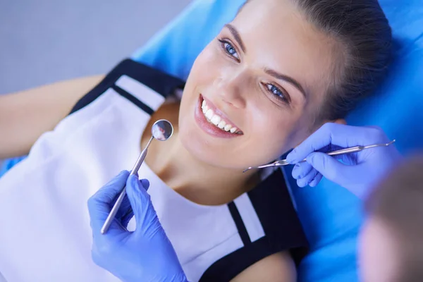 Jonge vrouwelijke patiënt met mooie glimlach onderzoeken tandheelkundige inspectie bij tandarts kantoor. — Stockfoto