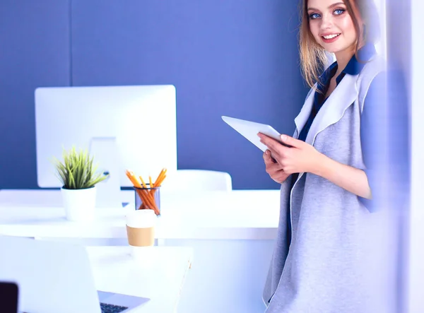 Junge Geschäftsfrau steht im Büro vor einem Tisch — Stockfoto