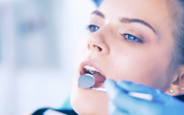 Mujer joven con la boca abierta examinando la inspección dental en el consultorio del dentista. — Foto de Stock