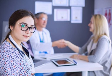 Doktor ve hasta masada otururken bir şey tartışıyorlar. İlaç ve sağlık hizmetleri kavramı