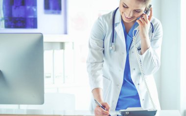 Telefonda konuşan gülümseyen güzel bir hemşirenin portresi.