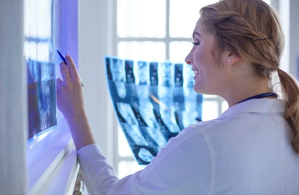 Dokter wanita profesional muda memeriksa pasien x-ray — Stok Foto