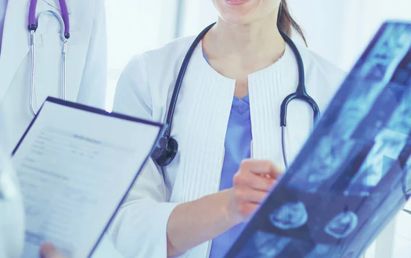 Médecins souriants discutant du diagnostic des patients regardant les rayons X dans un hôpital — Photo