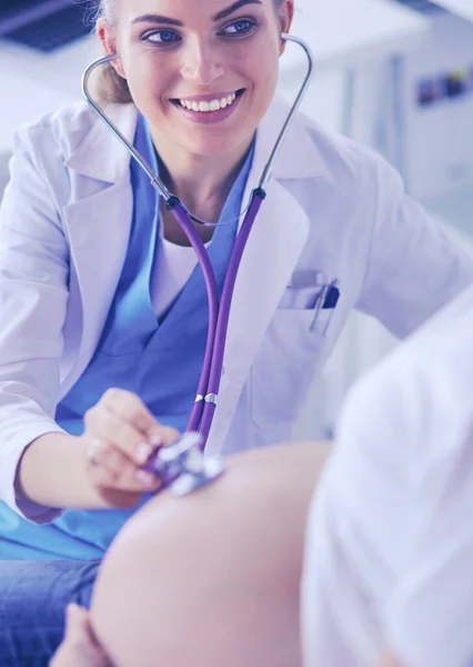 Jovem médica examinando mulher grávida na clínica. — Fotografia de Stock