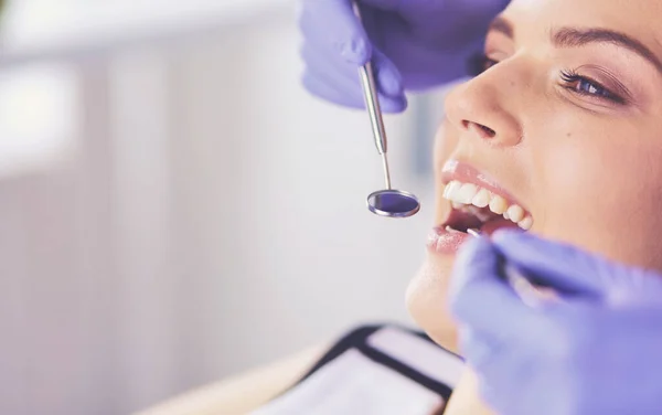 Mujer joven con la boca abierta examinando la inspección dental en el consultorio del dentista. — Foto de Stock