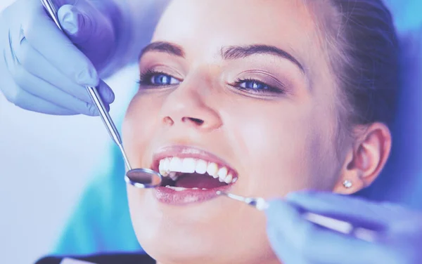 Mujer joven con la boca abierta examinando la inspección dental en el consultorio del dentista. — Foto de Stock