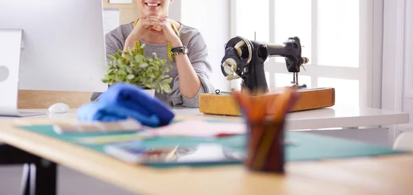 Belle jeune fille dans une usine avec une machine à coudre à la table — Photo