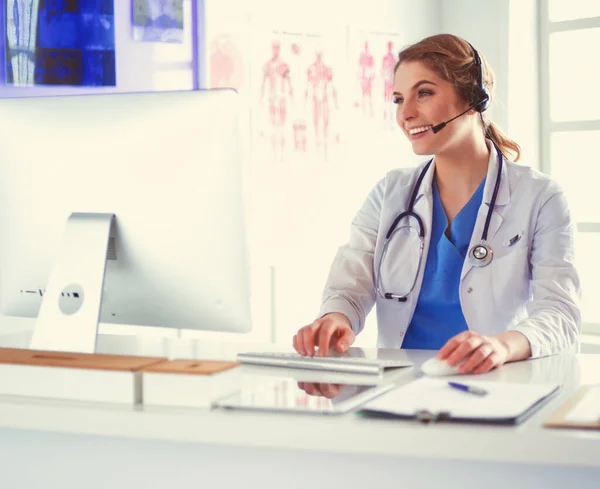 Jonge arts arts werkzaam bij de receptie van de kliniek, ze is het beantwoorden van telefoongesprekken en afspraken plannen — Stockfoto