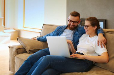 Mutlu çift evde dizüstü bilgisayarda bir şey arıyor.