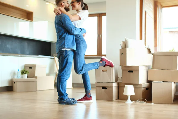 Счастливая пара обнимается в своем новом доме — стоковое фото