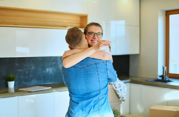 Pareja feliz abrazándose en su nueva casa — Foto de Stock