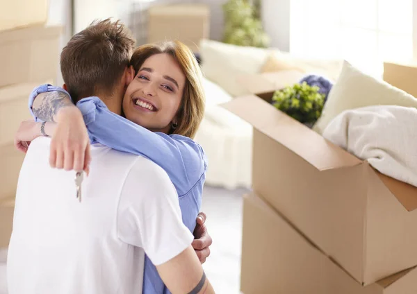 Casal feliz mudando de casa, caixas ao redor, segurando chaves — Fotografia de Stock