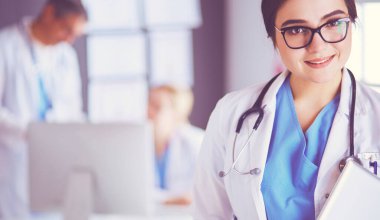 Hastane lobisinde tablet bilgisayar kullanan kadın doktor.